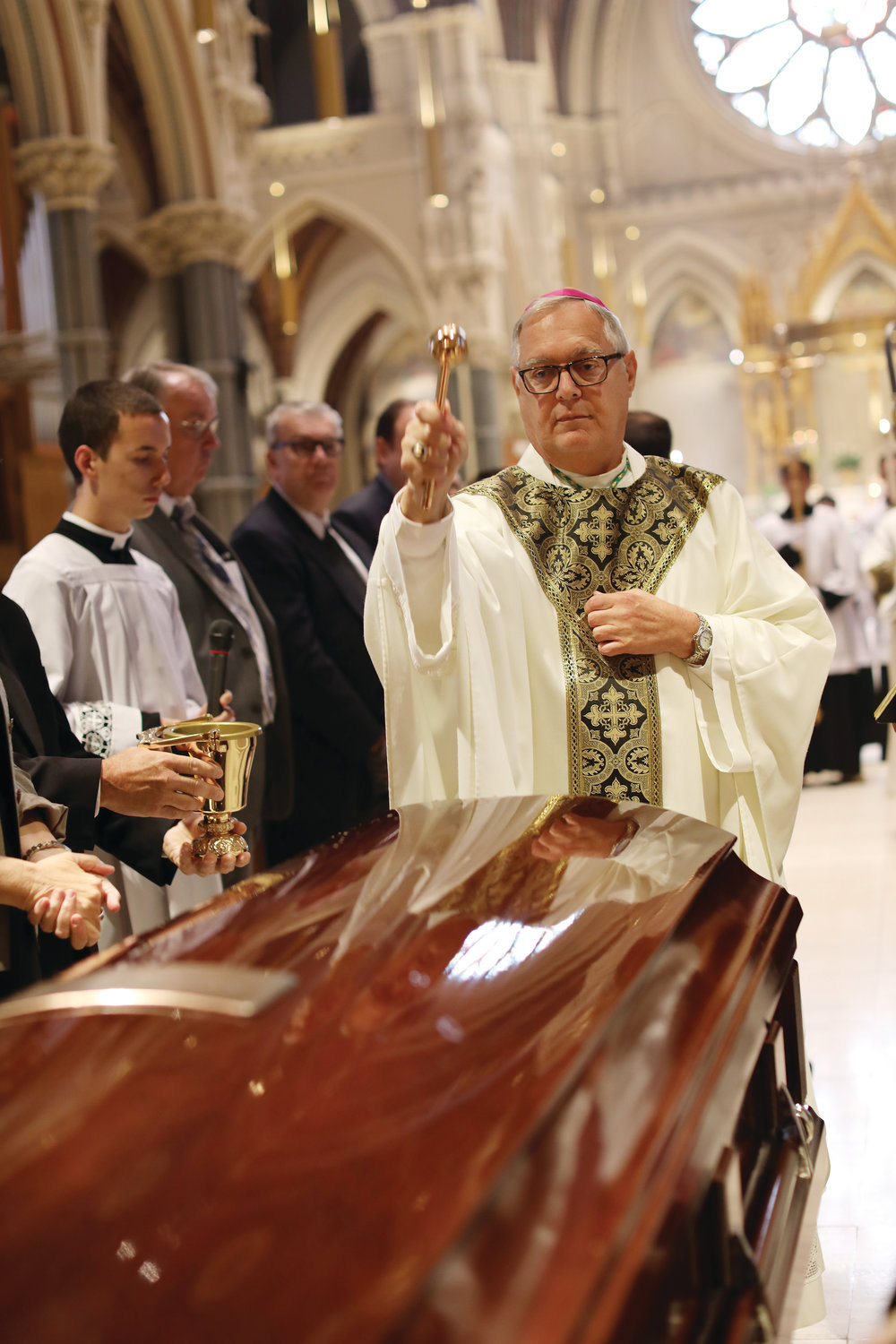 Bishop Thomas J. Tobin blesses the casket of Bishop Francis X. Roque at the start of the funeral Mass celebrated on Thursday, Sept. 19 in the Cathedral of SS. Peter and Paul, Providence.